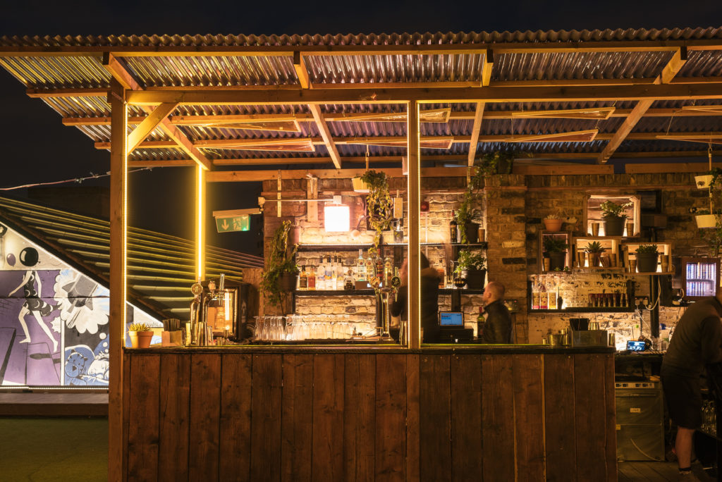 Bespoke lighting design bu Michael Grubb Studio transforms Dalston Roofpark into a dynamic event space, using warm-toned filters, integrated LEDs, and sustainable solutions to enhance the atmosphere after dark.