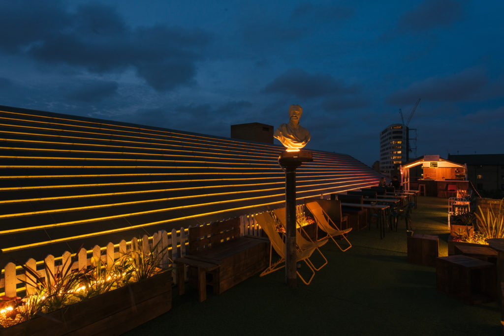 Bespoke lighting design bu Michael Grubb Studio transforms Dalston Roofpark into a dynamic event space, using warm-toned filters, integrated LEDs, and sustainable solutions to enhance the atmosphere after dark.