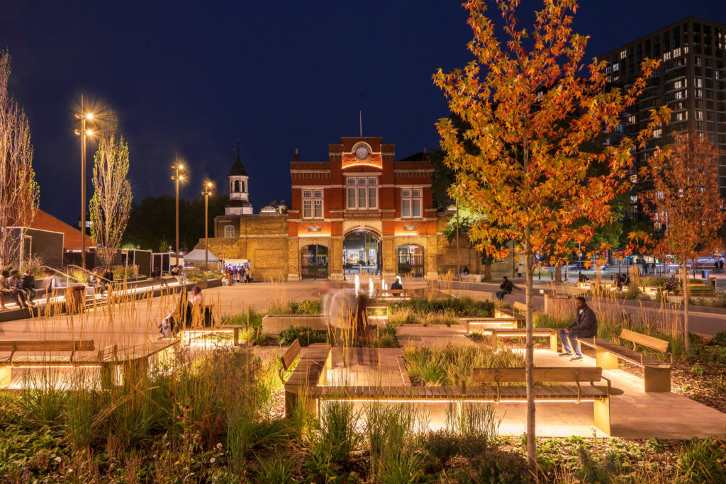 Public realm lighting design from Michael Grubb Studio for Woolwich Town Centre in London showing a regenerated civic square with warm and inclusive illumination